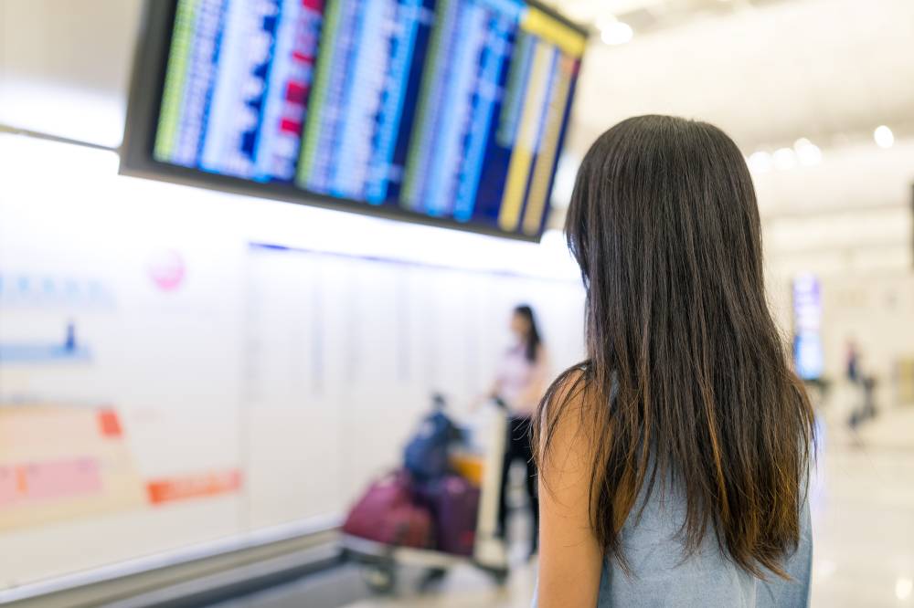 Young Woman looking at the flight number in airport