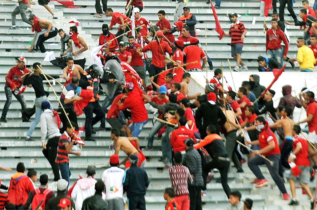 Fans of Morocco's Wydad Casablanca football club attack a policeman during riots between fans and the police following a football match between Wydad Casablanca and Raja Casablanca club at the Mohammed V stadium in Casablanca on December 20, 2015. AFP PHOTO / STR / AFP / STR (Photo credit should read STR/AFP via Getty Images)