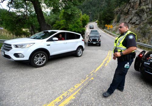 Boulder Police Officer Rodgers directs traffic as people evacuate Magnolia Road as a wildfire burns near Nederland on Sunday. Jeremy Papasso/ Staff Photographer July 10, 2016